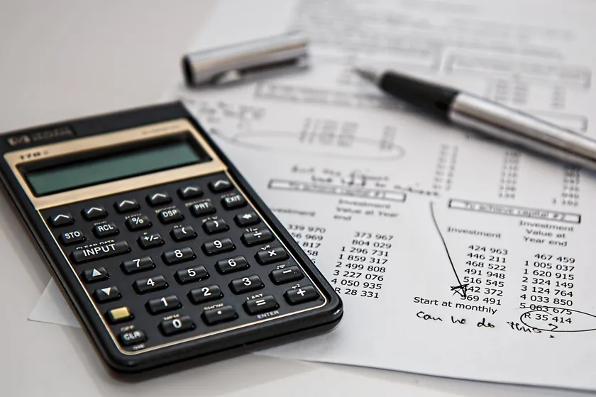 Calculadora y documentos financieros sobre una mesa de trabajo