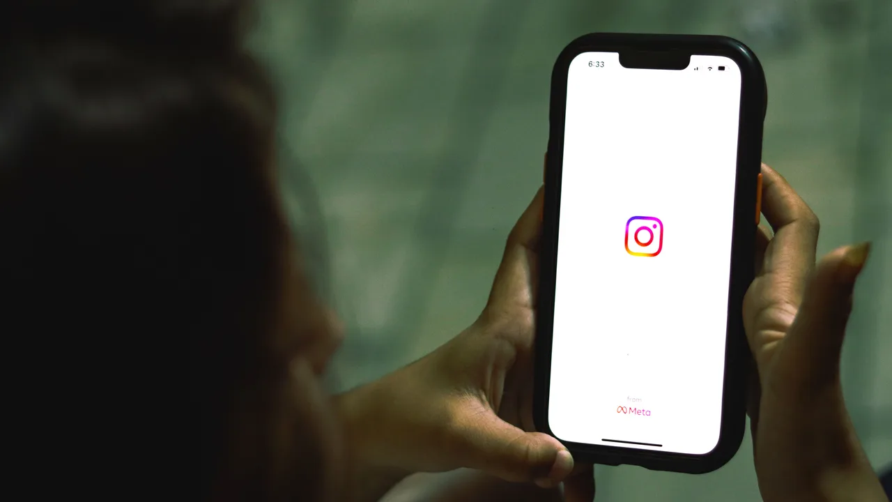 Mà sostenint un smartphone amb la icona d’Instagram a la pantalla
