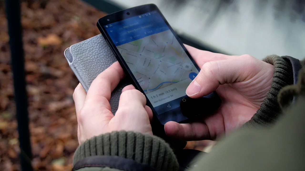 Persona consultant Google Maps al mòbil per localitzar una adreça
